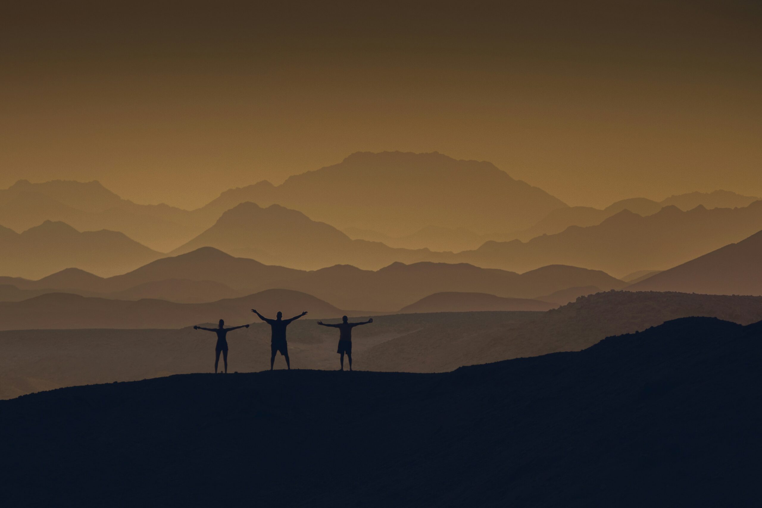 photo d'un paysage, d'une montagne avec trois silhouettes